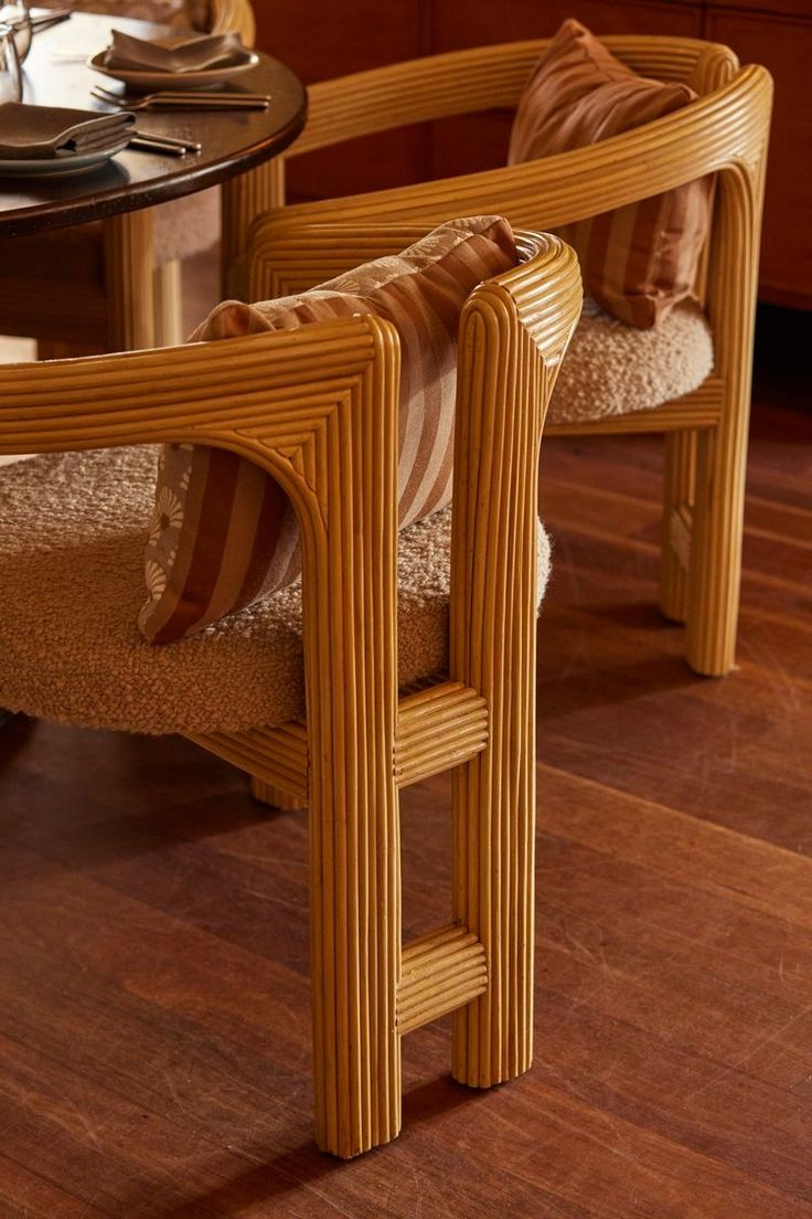 a wooden chair sitting on top of a hard wood floor next to a glass table