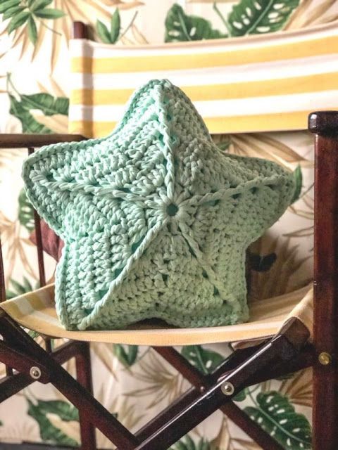 a green crocheted blanket sitting on top of a wooden chair