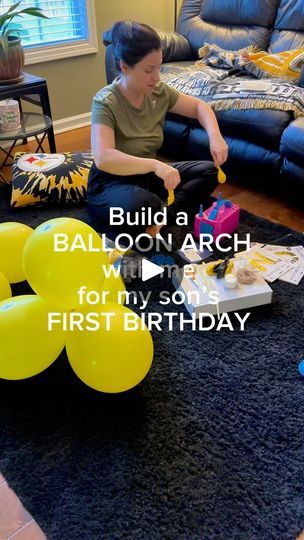 a woman is sitting on the floor with balloons in front of her, and she is holding a yellow balloon