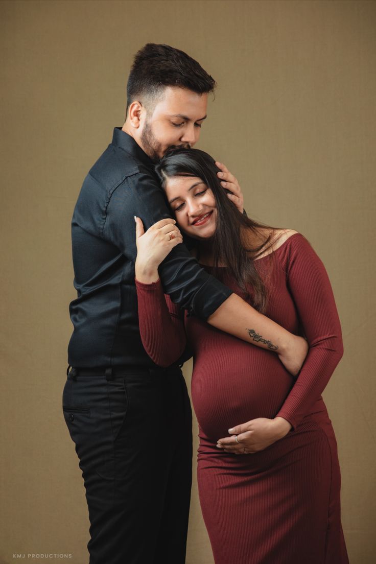 a pregnant woman hugging her husband's chest