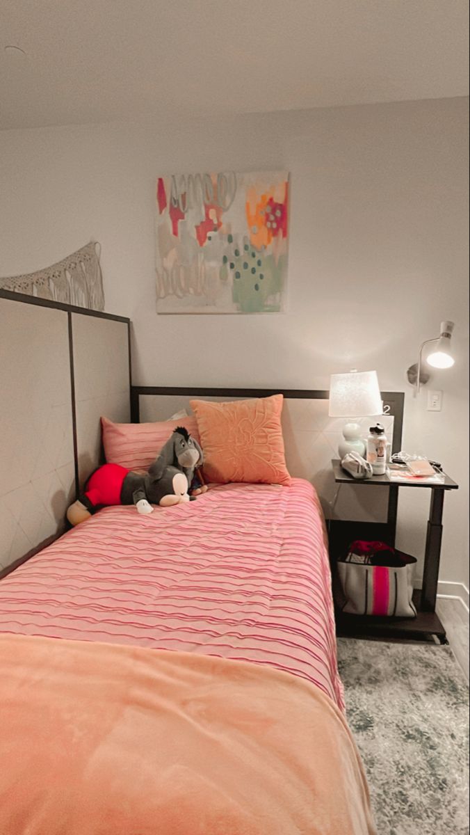 a bedroom with a bed, nightstands and pictures on the wall above it is shown