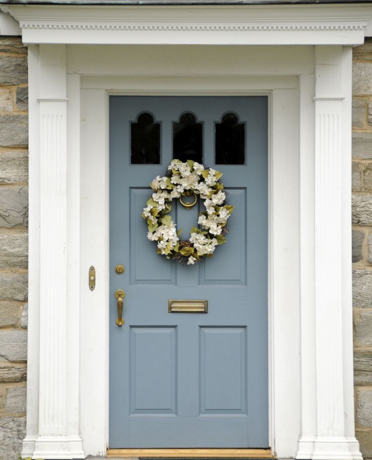 a blue front door with a wreath on it