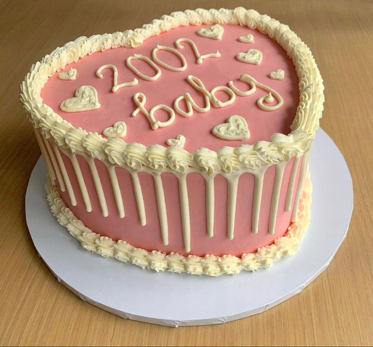 a heart shaped cake with the words boo boo written on it, sitting on top of a white plate