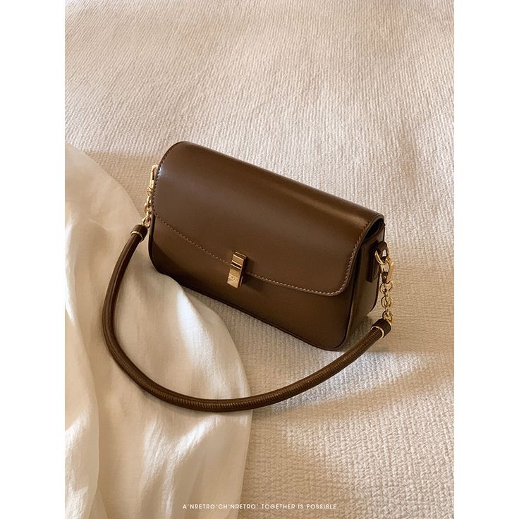 A shoulder bag with a square body and a flap that can hold a smartphone and a small wallet. The golden clasp and small design give it an elegant and stylish impression. It is also possible to remove the shoulder strap. 
 
 
 ＜Color＞ 
 
 Dark brown 
 Black 
 
 
 ＜Size＞ 
 
 
 FREE size 
 
 Height: 14cm 
 Width: 22cm 
 Depth: 6.5cm 
 
 
 
 
 
 ＜Material＞ 
 
 Leather Rectangular Shoulder Bag With Gold-tone Hardware For Daily Use, Classic Rectangular Flap Bag With Chain Strap, Classic Gold Rectangular Shoulder Bag, Formal Beige Rectangular Flap Bag, Classic Gold Bags With Mobile Phone Holder, Classic Gold Bag With Mobile Phone Pocket, Classic Gold Bag With Mobile Phone Holder, Trendy Rectangular Flap Bag, Trendy Formal Baguette Mobile Phone Bag