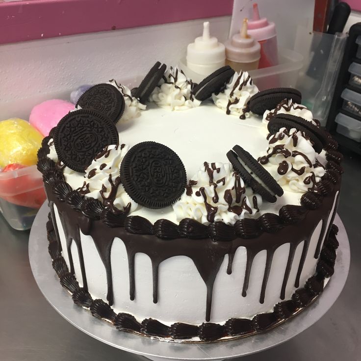 an oreo cookie cake with white frosting and chocolate drizzle