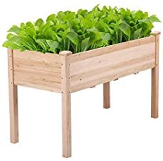 a wooden planter filled with lots of green plants