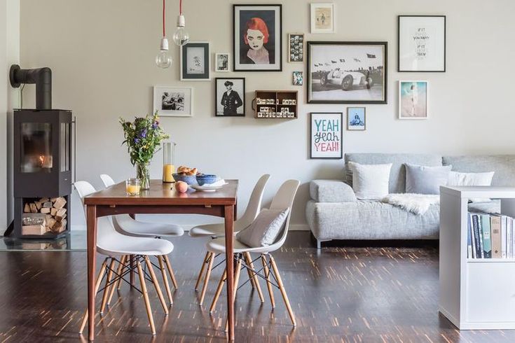 a living room filled with furniture and pictures on the wall above a wooden dining table