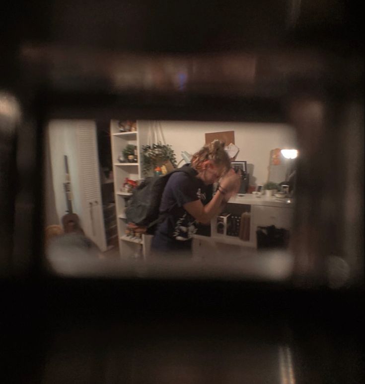 a man and woman kissing in the reflection of a microwave oven