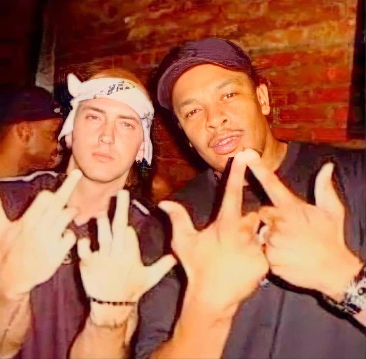 two men making the peace sign with their hands