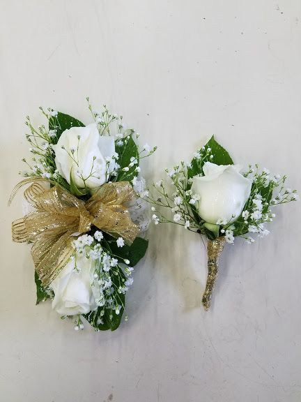 two white roses and baby's breath are placed on the wall next to each other