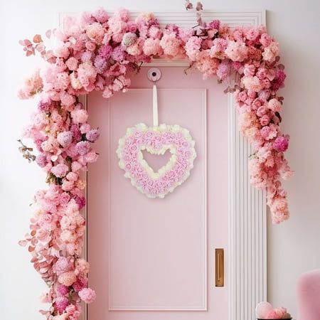 a pink door decorated with flowers and a heart