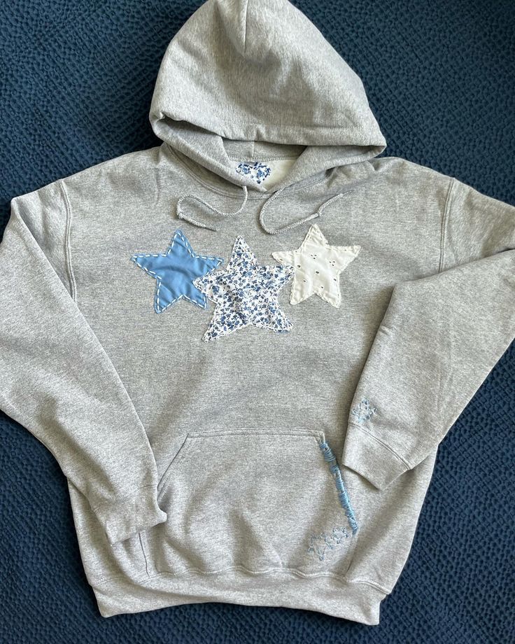 a gray sweatshirt with blue and white stars on it