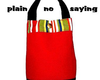 a red bag with a black handle and striped pocket on the front, which says plain no saying