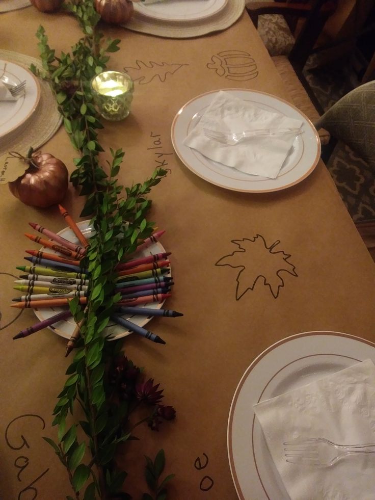 the table is set with white plates and place settings for an autumn themed dinner party