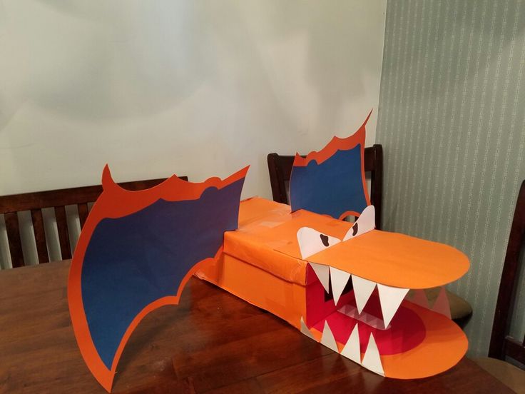 an orange and blue dragon chair sitting on top of a wooden table