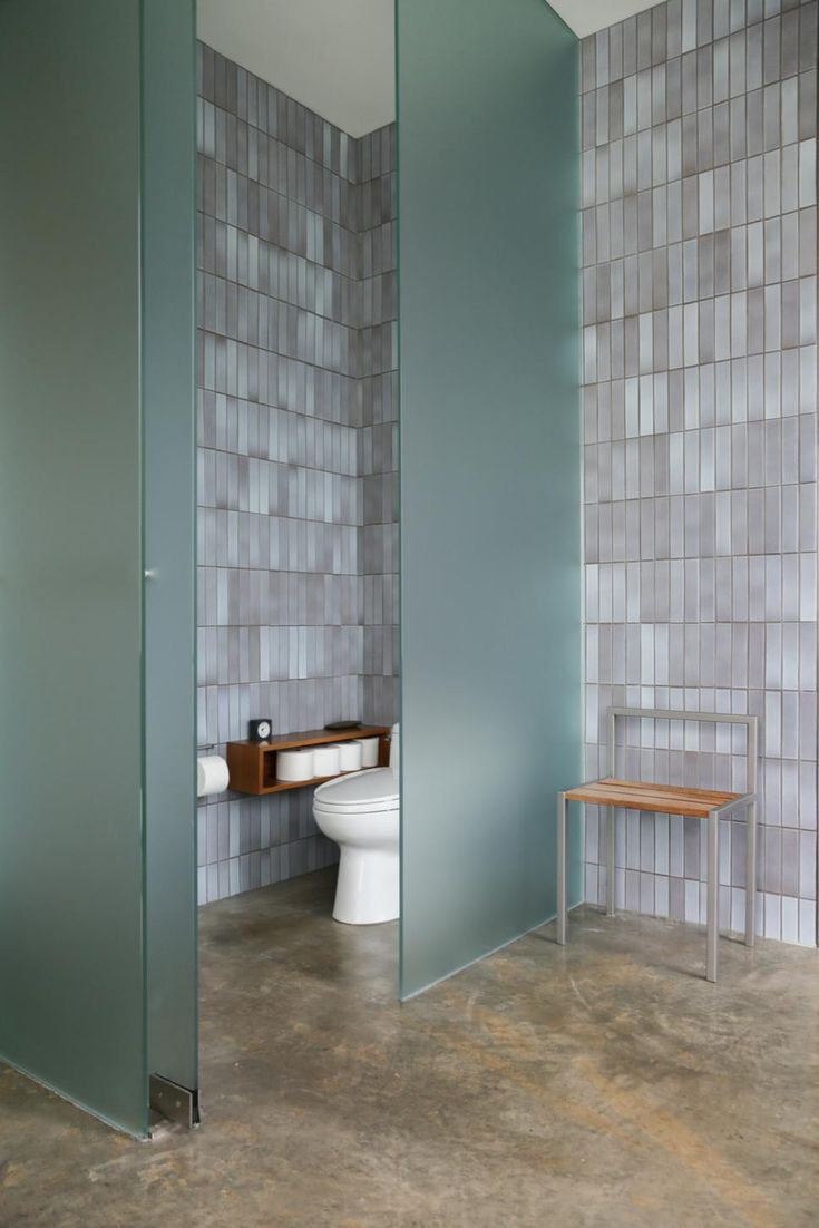 a bathroom with a toilet, sink and mirror