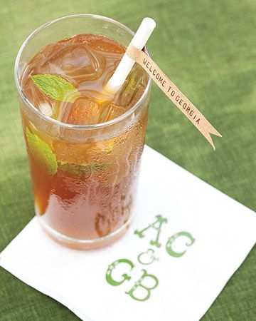 a glass filled with ice and mint sitting on top of a napkin