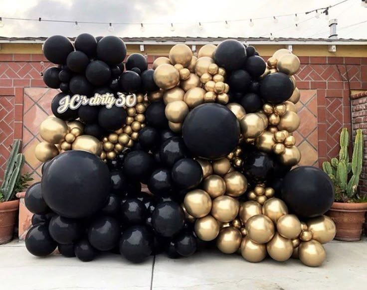 black and gold balloons are stacked on top of each other in front of a building