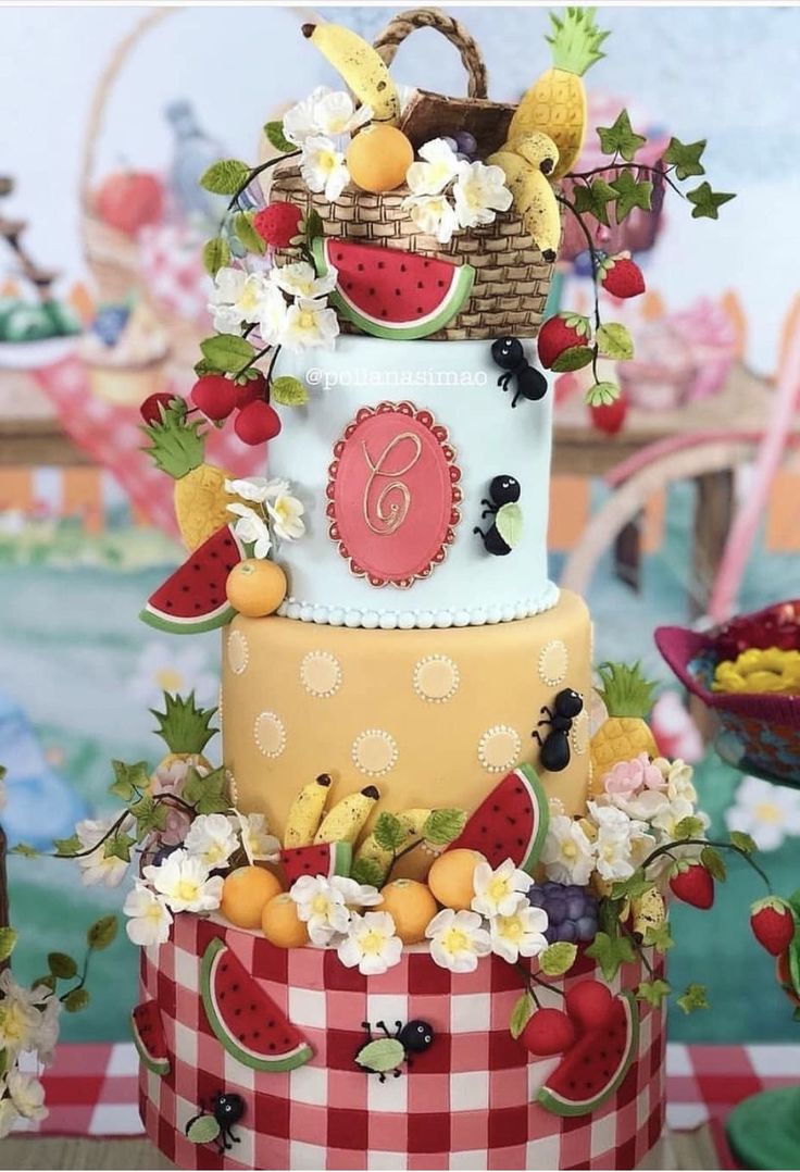 a three tiered cake decorated with fruit and flowers