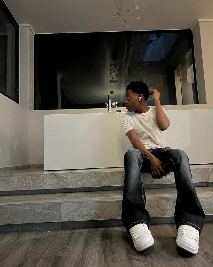 a man sitting on the floor talking on his cell phone