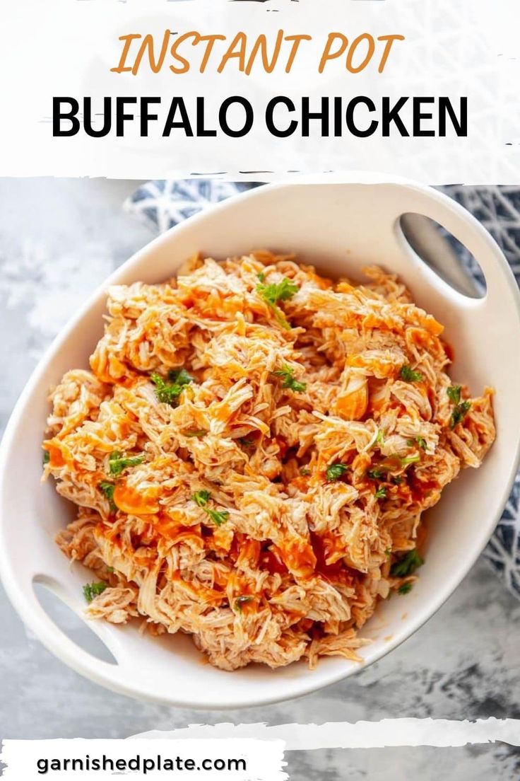 a white bowl filled with shredded chicken and garnished with parsley next to spoons