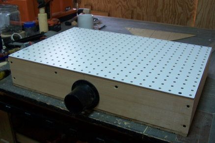 a wooden box sitting on top of a table with holes in it's sides