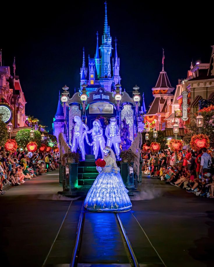 a woman in a blue dress is on the train at disneyland's christmas parade