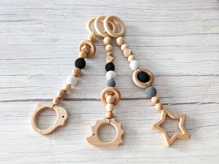 the wooden toys are hanging on the white wood floor with black and grey beads in them