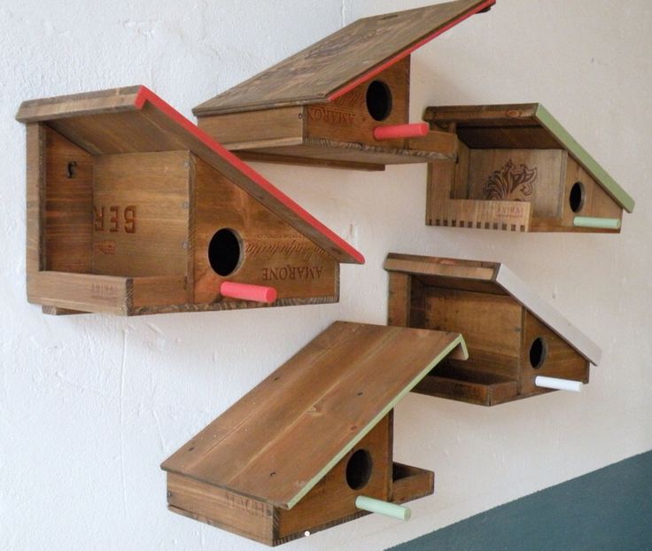 three wooden bird houses hanging on the wall