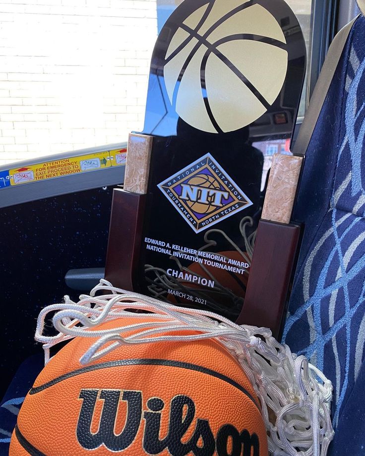 an orange basketball sitting on top of a blue chair next to a trophy and plaque