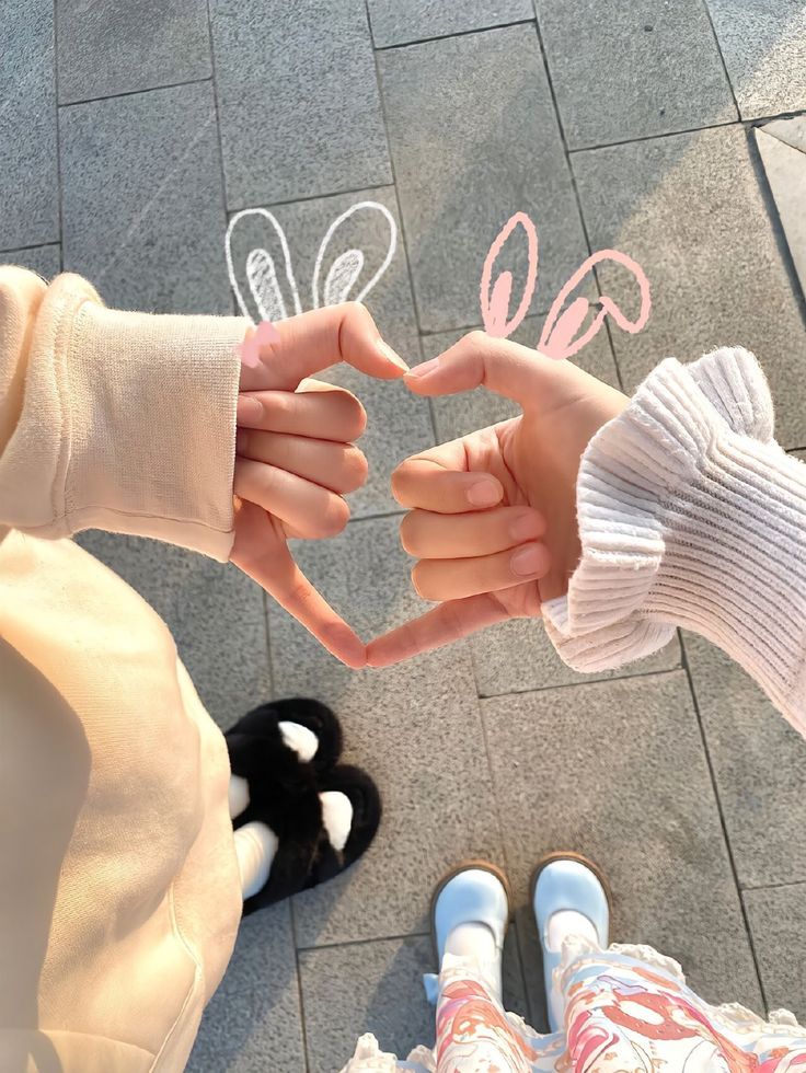 two people holding hands with the word love written on them in front of their faces