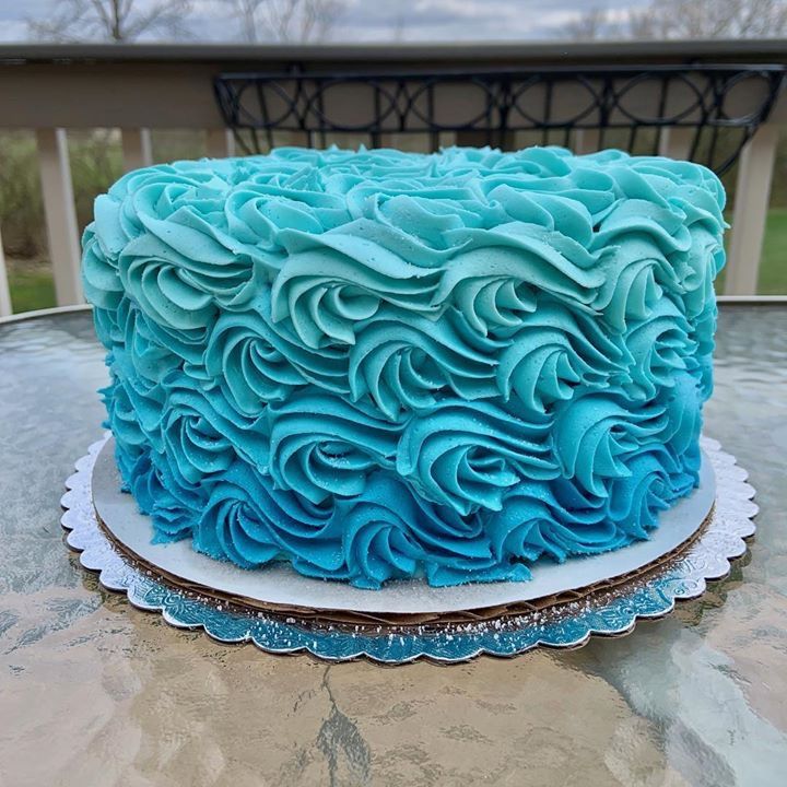 a blue frosted cake sitting on top of a table