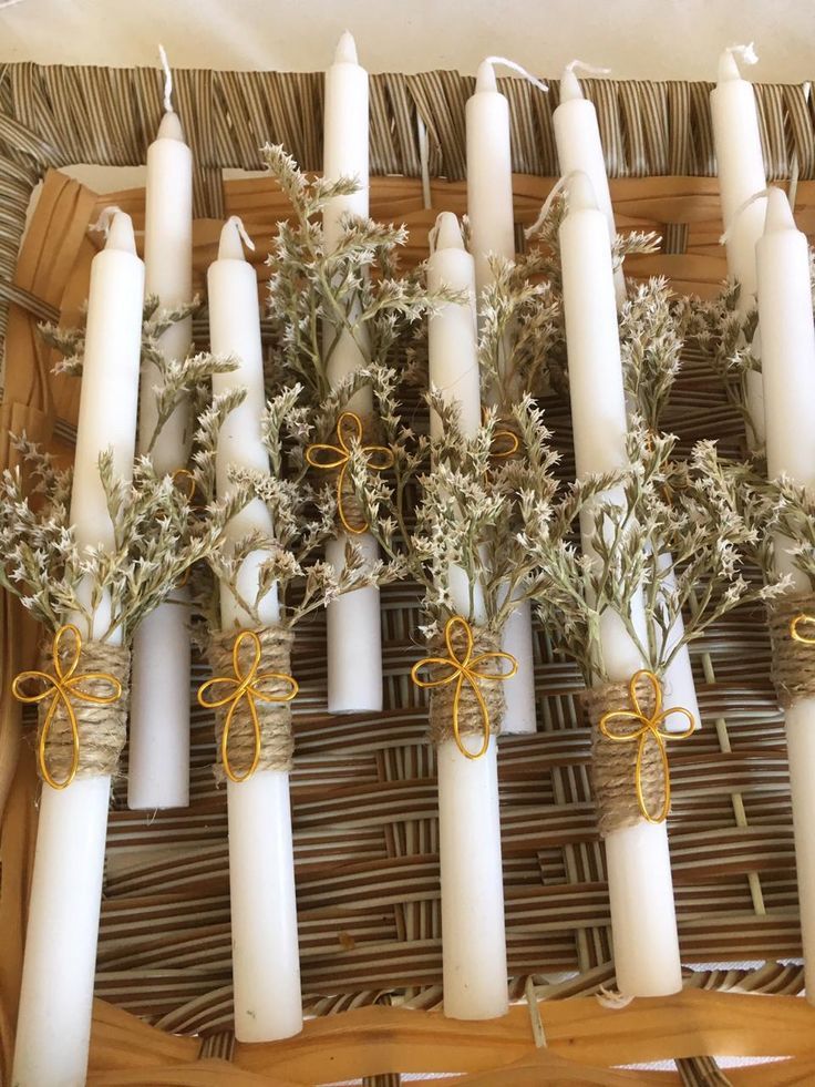 some white candles are sitting in a wicker basket