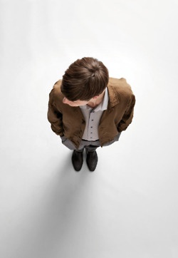 a man sitting down with his head in his hands