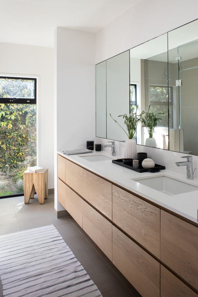 a bathroom with two sinks and large mirrors