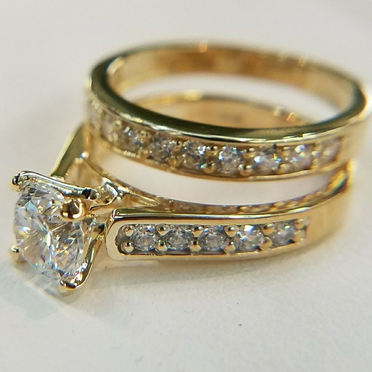 two gold wedding rings with diamonds on each one and an engagement ring in the middle