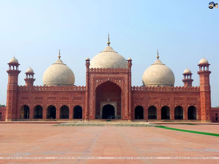 a large red building with two domes on it's sides and people standing in front