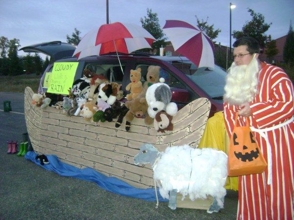 a man dressed in costume standing next to a boat filled with stuffed animals