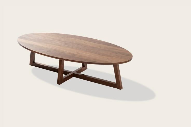 an oval wooden table sitting on top of a white floor