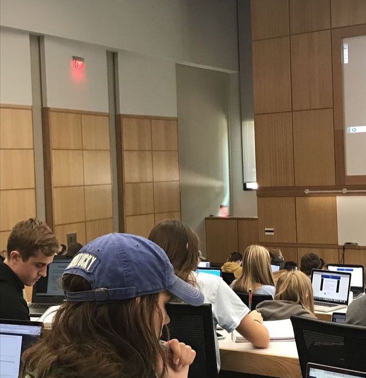 several people sitting at desks with computers in front of them