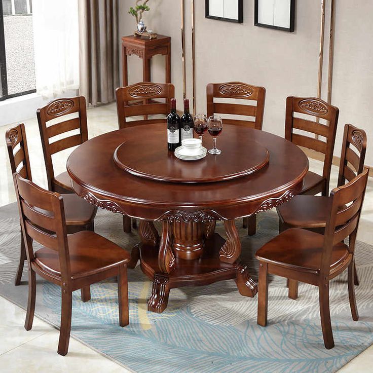 a dining room table and chairs with wine bottles on the top one chair is empty