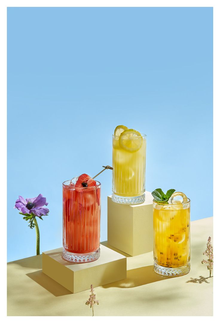 three different types of drinks sitting on top of each other in front of a blue sky