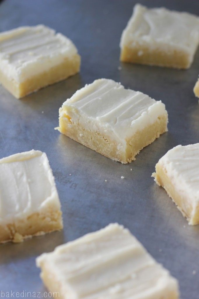 several pieces of white cake sitting on top of a metal pan covered in frosting