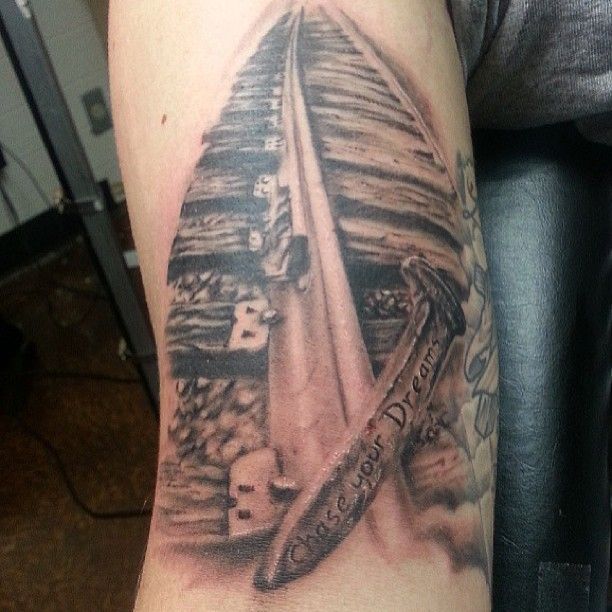 a man's arm with a boat on it and some words in the middle