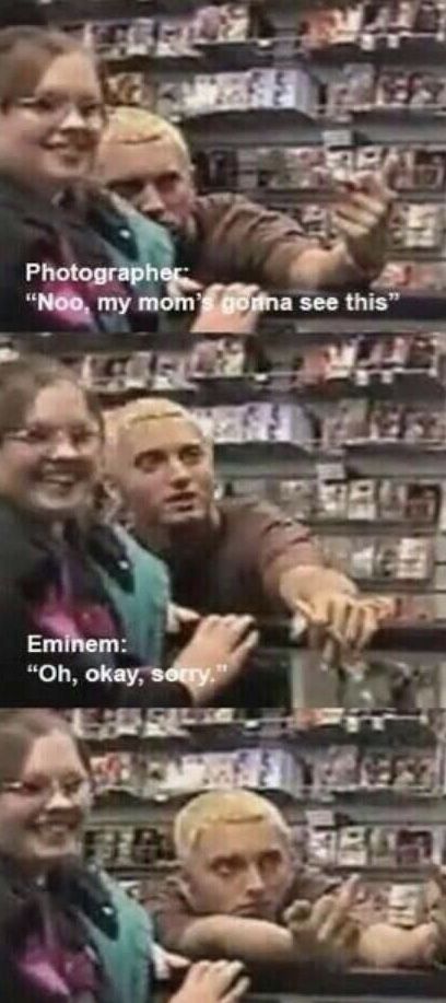 two people are talking to each other in front of some shelves with cameras on them