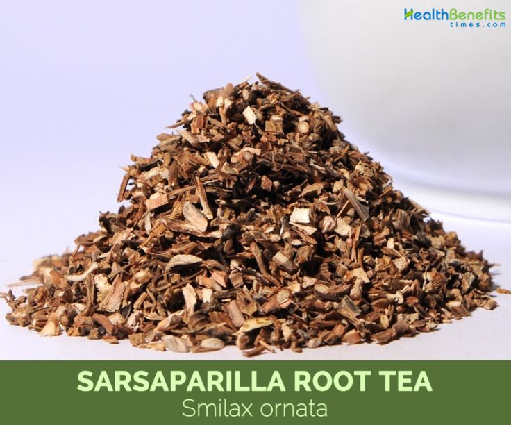 a pile of wood shavings next to a white bowl with the words sarsaparilla root tea on it