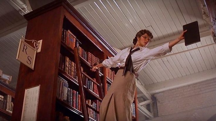 a woman standing in front of a book shelf