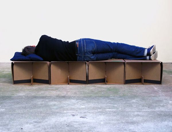 a man laying on top of a cardboard box