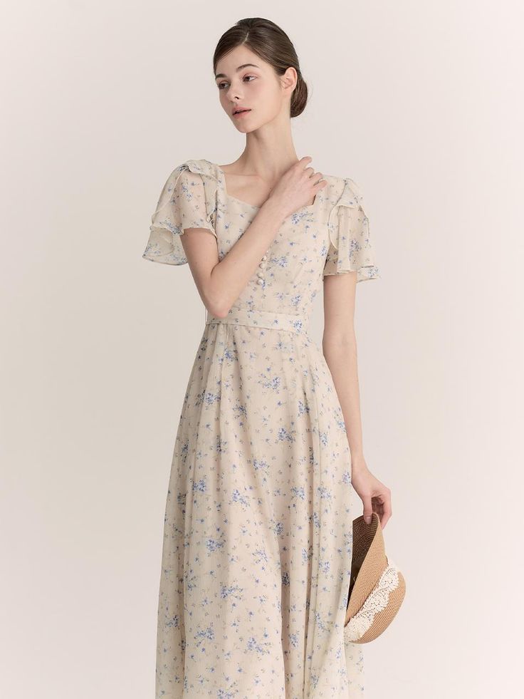 The Blanc Dress is a quintessential piece for a graceful, timeless wardrobe. It features a delicate floral print scattered across a light blue fabric, offering a soft, romantic vibe. The dress is designed with short flutter sleeves and a square neckline, enhancing its feminine charm. Its mid-length skirt gently flares from a cinched waist, creating a flattering silhouette perfect for spring and summer occasions. - The floral pattern on the Blanc Dress is beautifully detailed, adding a touch of elegance and subtlety to its overall design.- Crafted from lightweight fabric, the dress provides comfort and breathability, ideal for warmer weather.- Its flutter sleeves and square neckline contribute to the vintage-inspired aesthetic, making it perfect for both casual and more formal gatherin Light Blue Fabric, Inspired Aesthetic, Timeless Wardrobe, Dress Yellow, Mid Length Skirts, Flutter Sleeves, Cinched Waist, Yellow Dress, Blue Fabric