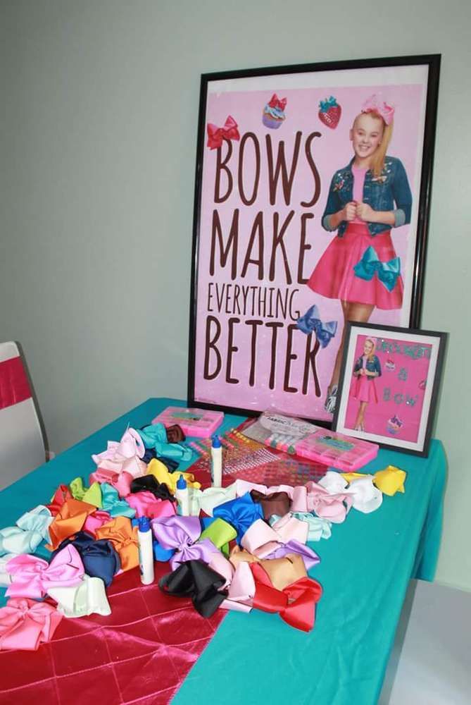 there is a table with bows on it and a sign above it that says bow make everything better